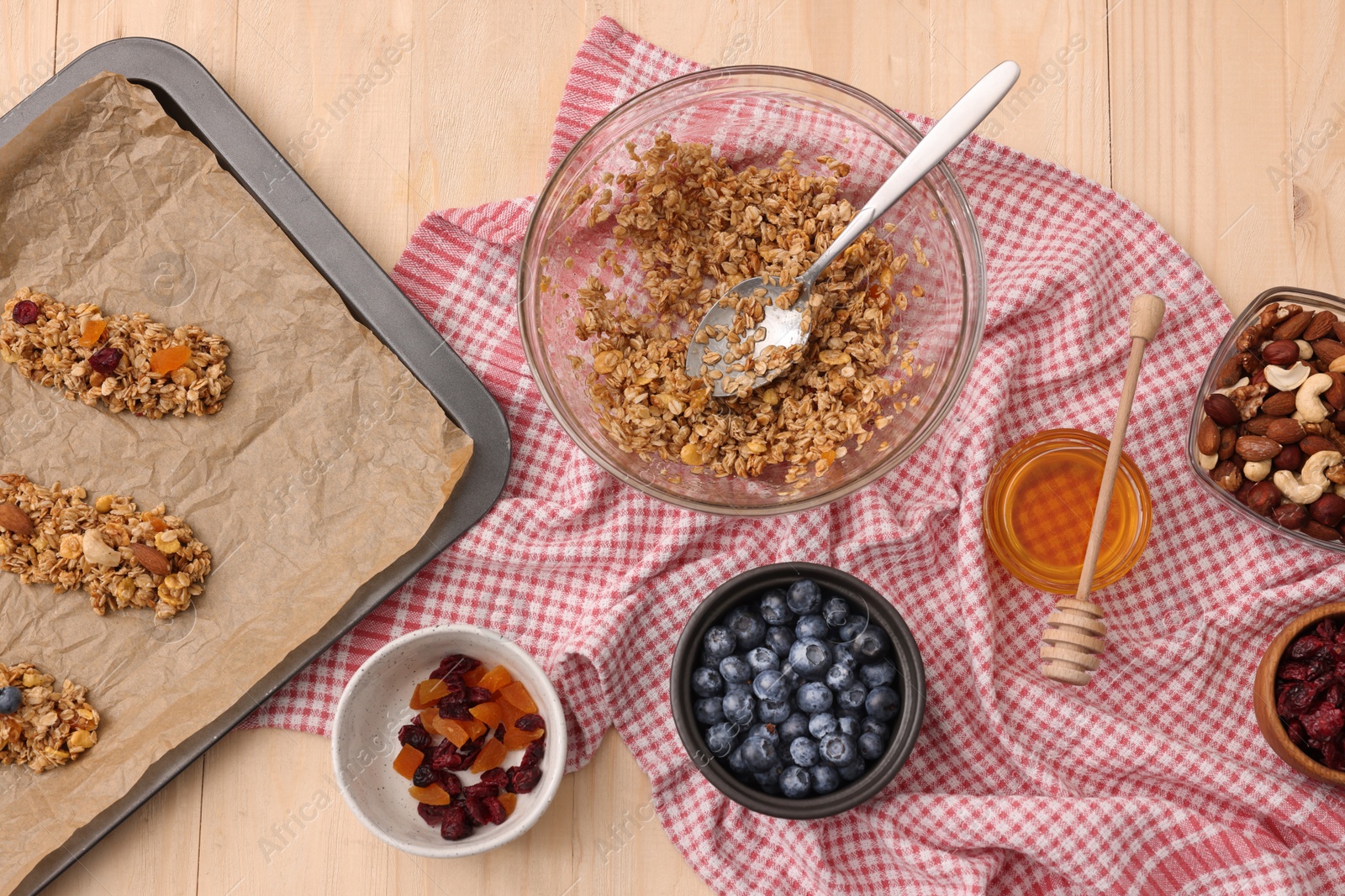 Photo of Making granola bars. Baking tray and ingredients on wooden table, flat lay