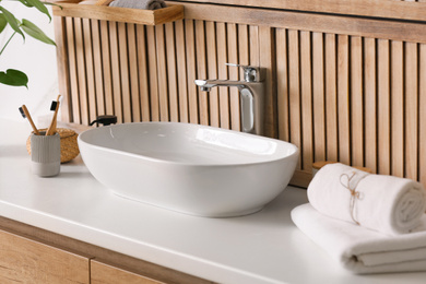 Stylish vessel sink near wooden wall in modern bathroom