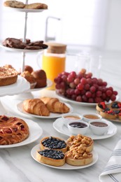 Photo of Variety of snacks on white marble table in buffet style indoors