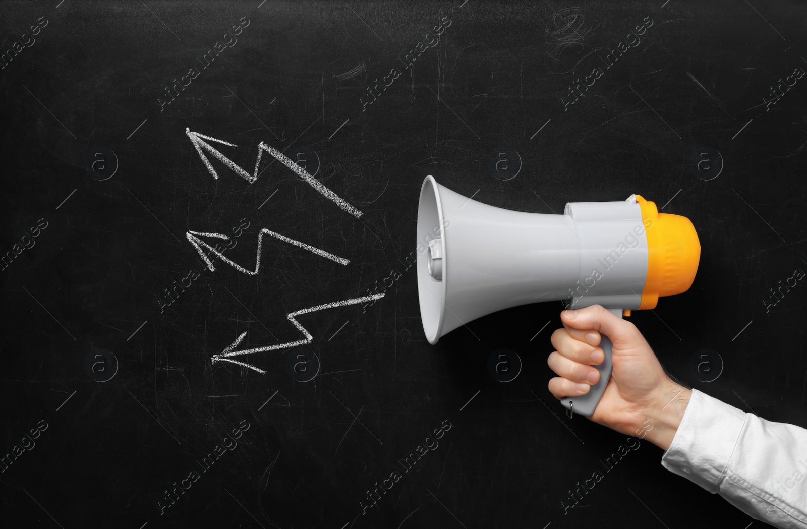 Photo of Man holding megaphone near chalkboard