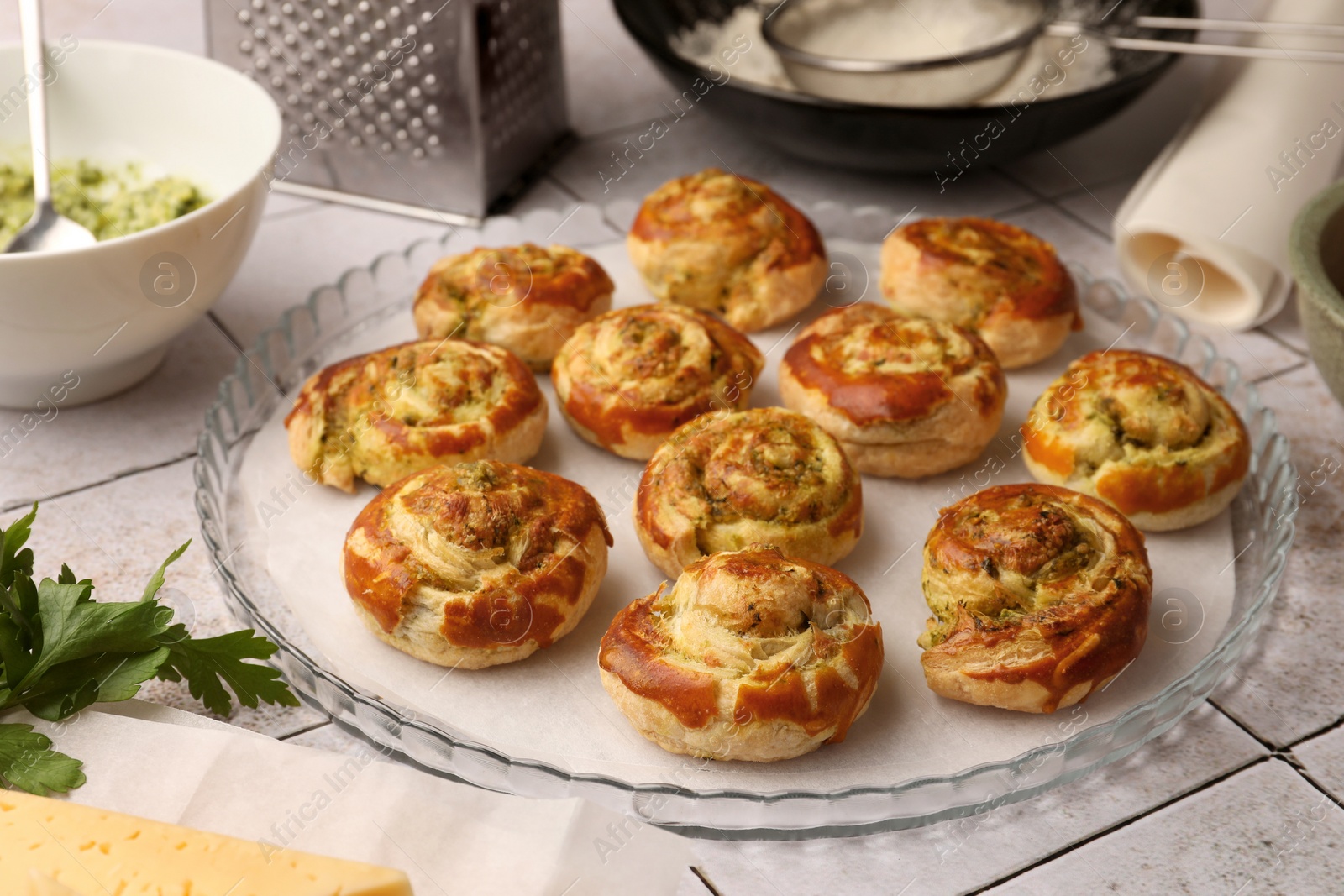 Photo of Fresh delicious puff pastry and ingredients on white tiled surface, closeup