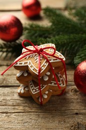 Photo of Tasty Christmas cookies with icing and festive decor on wooden table