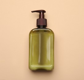 Photo of Bottle of shampoo on beige background, top view