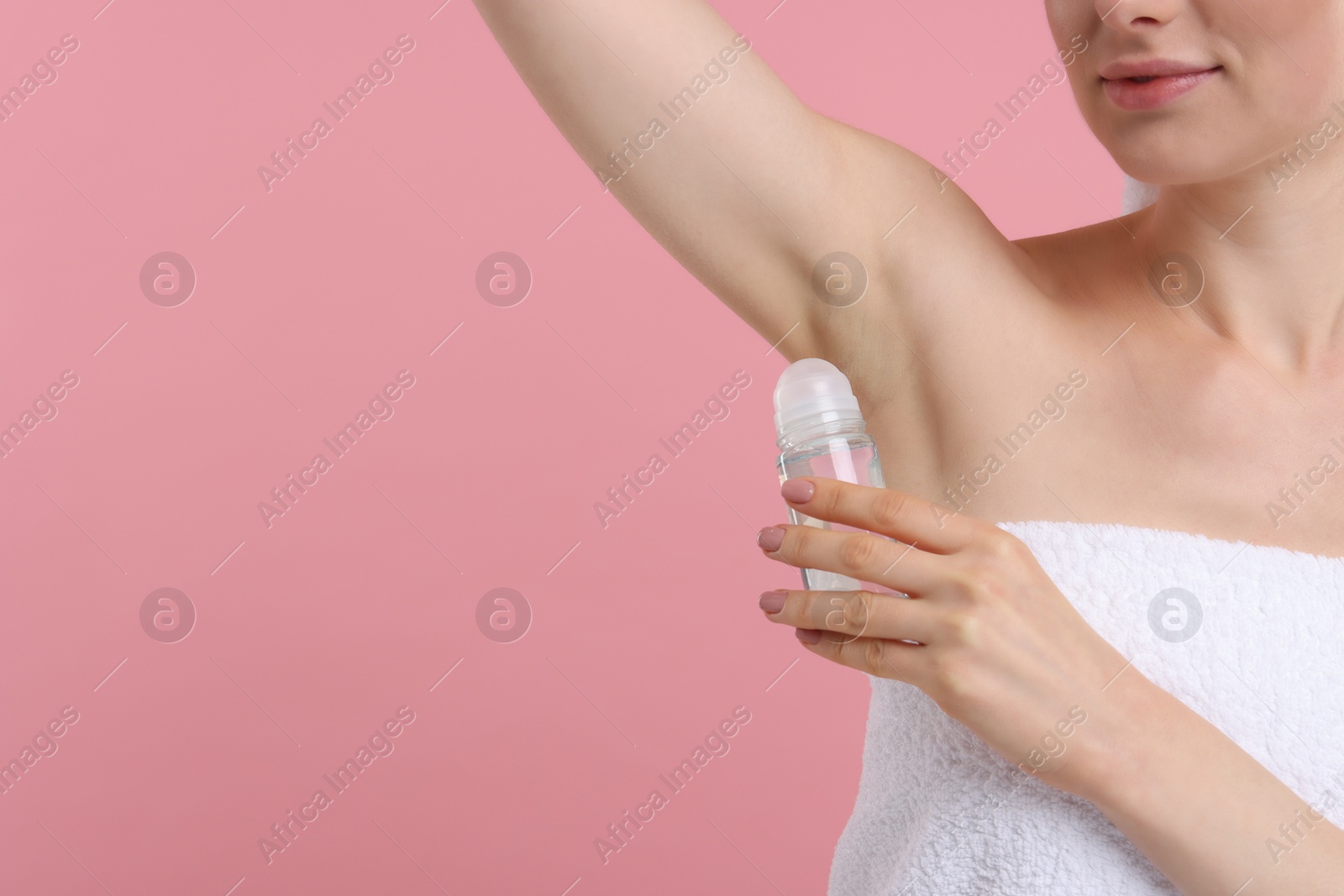 Photo of Woman applying deodorant on pink background, closeup. Space for text