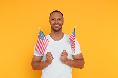 4th of July - Independence Day of USA. Happy man with American flags on yellow background