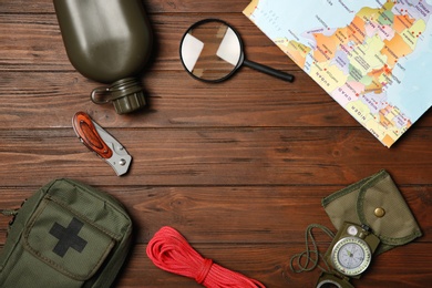 Photo of Flat lay composition with camping equipment on wooden background. Space for text
