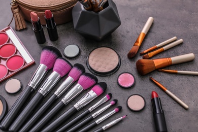 Photo of Makeup products and brushes on grey background