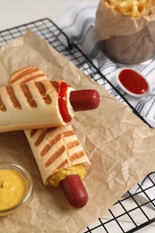 Photo of Delicious french hot dogs, fries and dip sauce on white wooden table