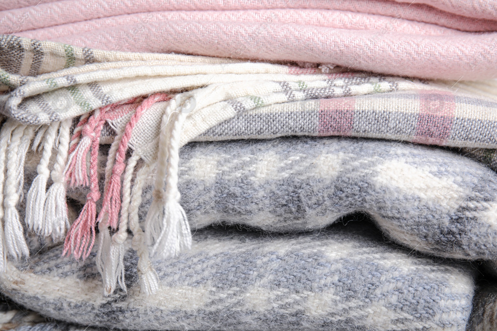 Photo of Stack of soft warm plaids as background, closeup