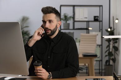Man talking on phone while working at table in office