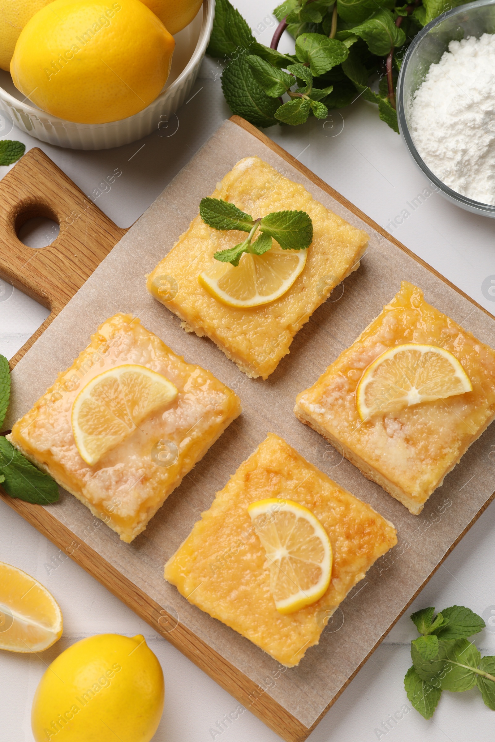 Photo of Tasty lemon bars with mint on white table, flat lay