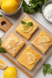 Photo of Tasty lemon bars with mint on white table, flat lay