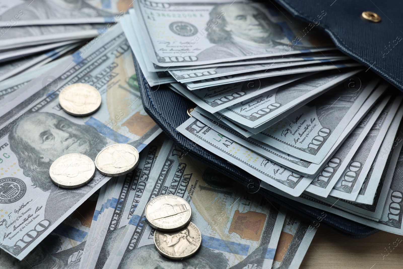 Photo of Dollar banknotes, coins and wallet on wooden table, closeup. Money exchange