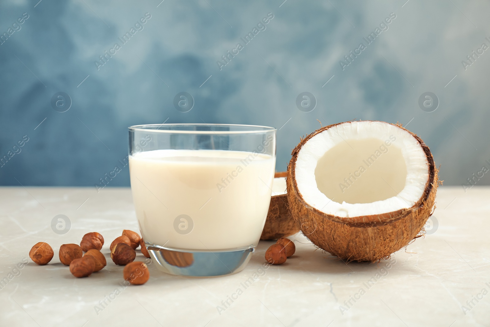 Photo of Glass with milk substitute and nuts on table