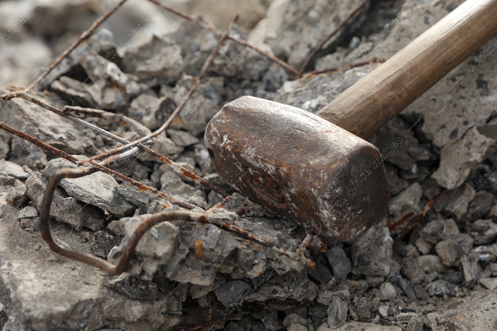 Photo of Sledgehammer on pile of broken stones outdoors, closeup