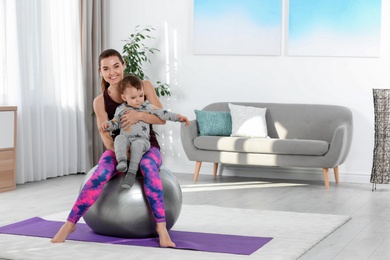 Woman doing fitness exercises together with son at home