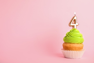 Photo of Birthday cupcake with number four candle on pink background, space for text