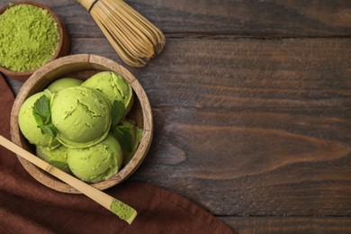 Photo of Tasty matcha ice cream, bamboo spoon with powder and whisk on wooden table, flat lay. Space for text