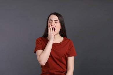 Photo of Portrait of bored young woman on dark grey background. Personality concept