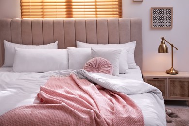 Photo of Cozy bed with soft linens in light room
