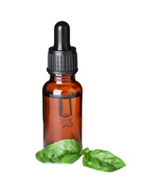 Little bottle of essential oil and basil on white background