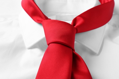 Photo of Red male necktie on white shirt, closeup