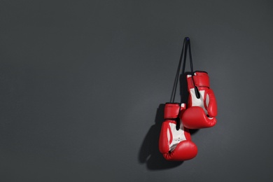 Pair of boxing gloves on grey background, space for text