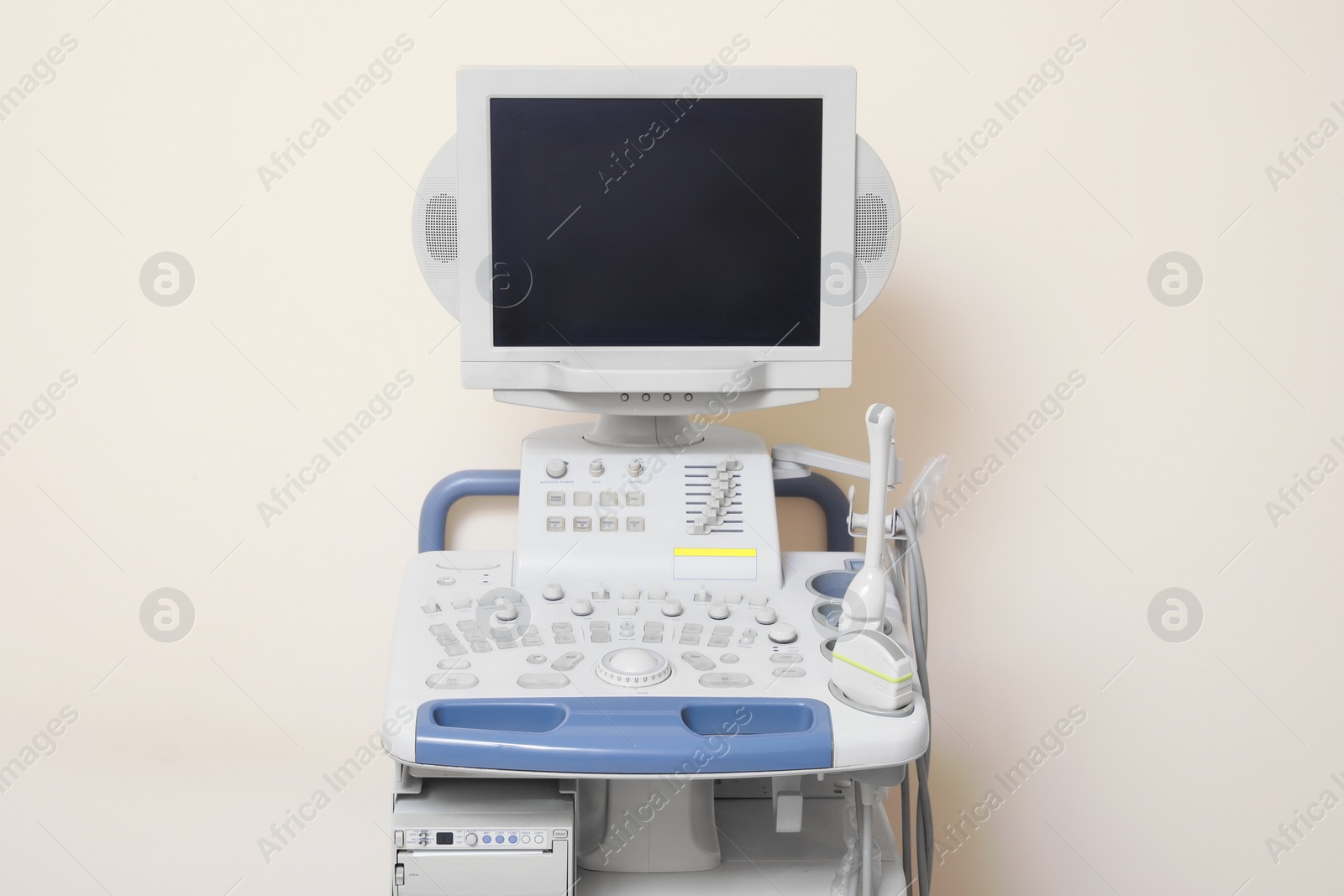 Photo of Ultrasound machine near white wall. Medical equipment