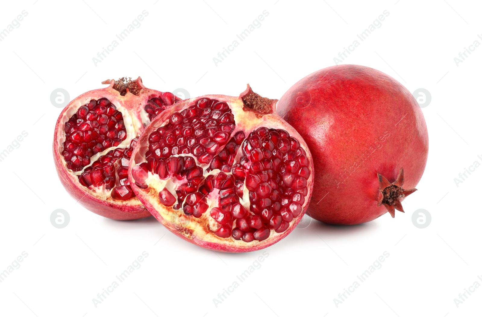 Photo of Halves and whole pomegranates isolated on white