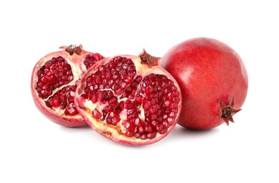 Halves and whole pomegranates isolated on white