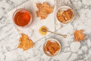 Photo of Flat lay composition with honey and combs on marble background