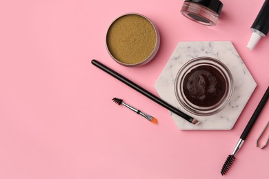 Photo of Flat lay composition with eyebrow henna and tools on pink background. Space for text