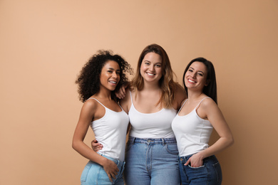 Group of women with different body types on beige background