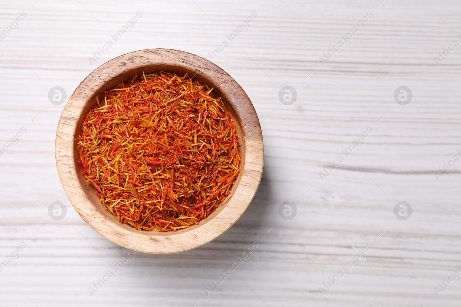 Photo of Aromatic saffron in bowl on table, top view. Space for text