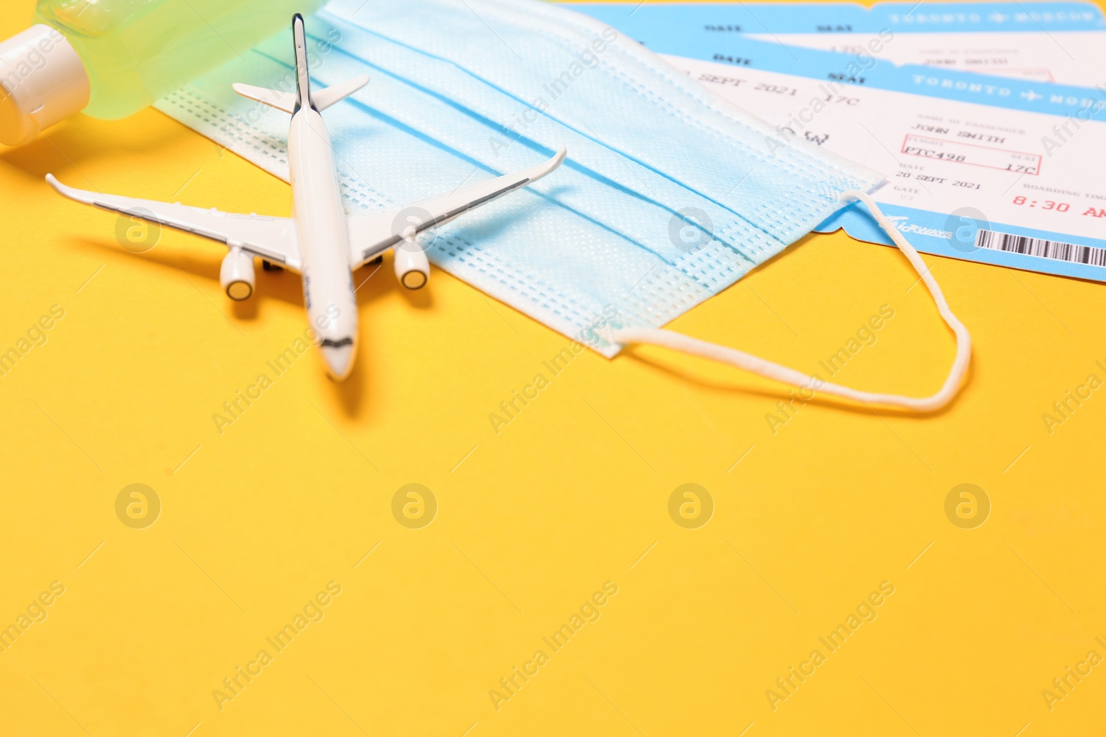 Photo of Composition with tickets and protective mask on yellow background, space for text. Travel during quarantine