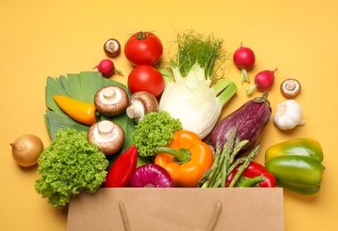 Photo of Different fresh vegetables on yellow background, flat lay