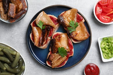 Tasty sandwiches with fried pork fatback slices on light grey table, flat lay