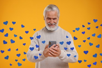 Long distance love. Man chatting with sweetheart via smartphone on golden background. Hearts flying out of device and swirling around him