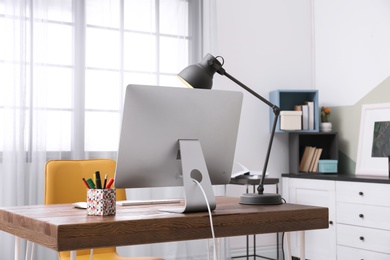 Photo of Comfortable workplace with computer on desk in home office