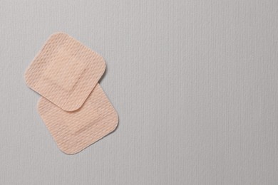 Photo of Contraceptive patches on light grey background, flat lay. Space for text