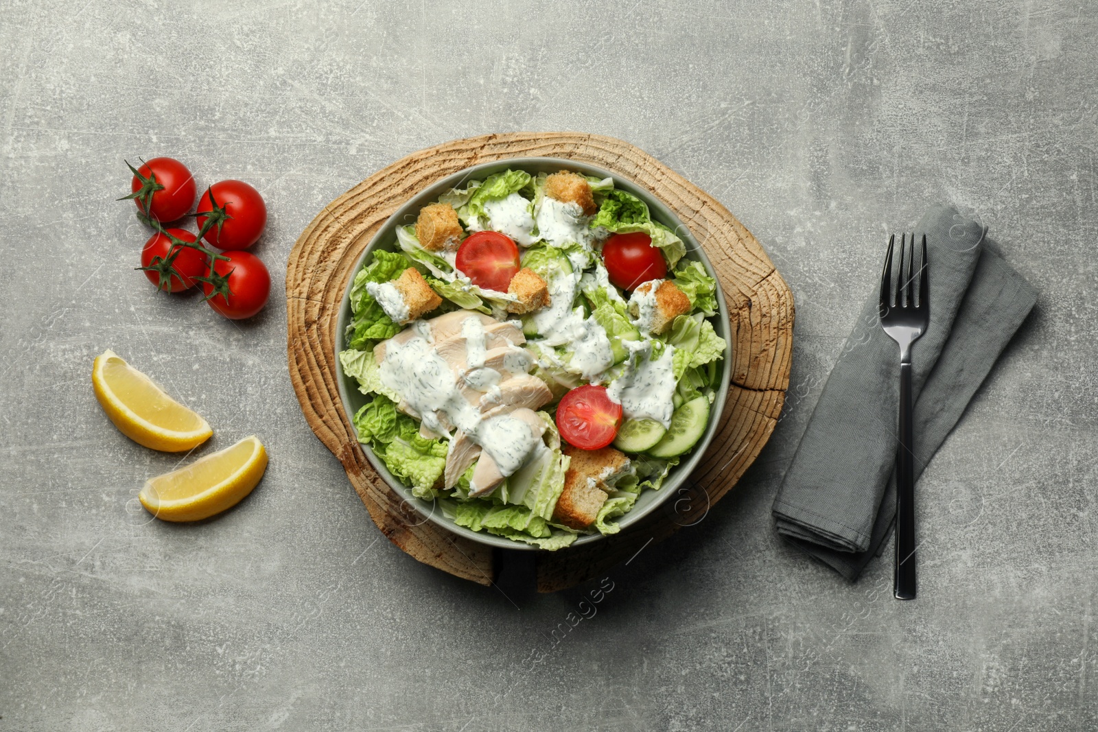 Photo of Delicious salad with Chinese cabbage, cucumber, meat and tomatoes served on grey table, flat lay