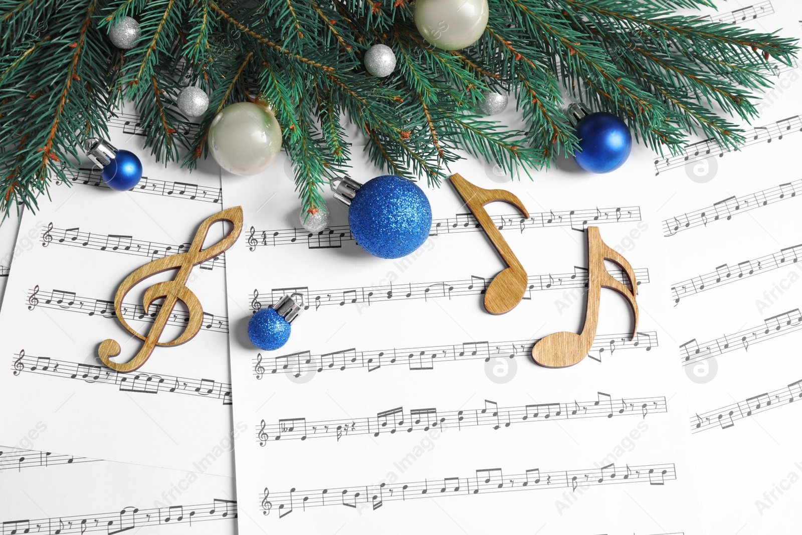 Photo of Flat lay composition with Christmas decorations and wooden music notes on sheets