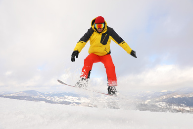Photo of Male snowboarder on snowy hill. Winter vacation