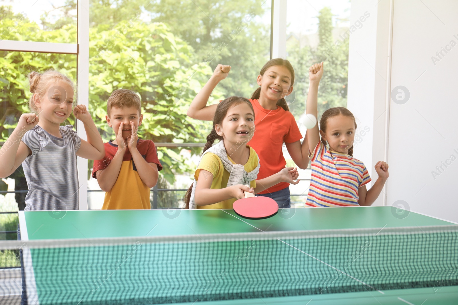 Photo of Cute happy children playing ping pong indoors