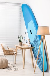 Photo of SUP board and workplace in room. Interior design