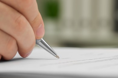 Man signing document, closeup view. Space for text