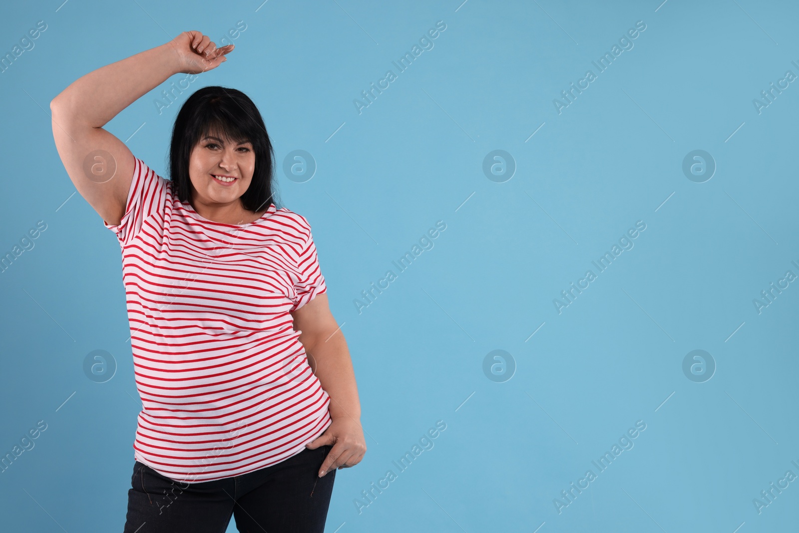 Photo of Beautiful overweight mature woman with charming smile on turquoise background. Space for text