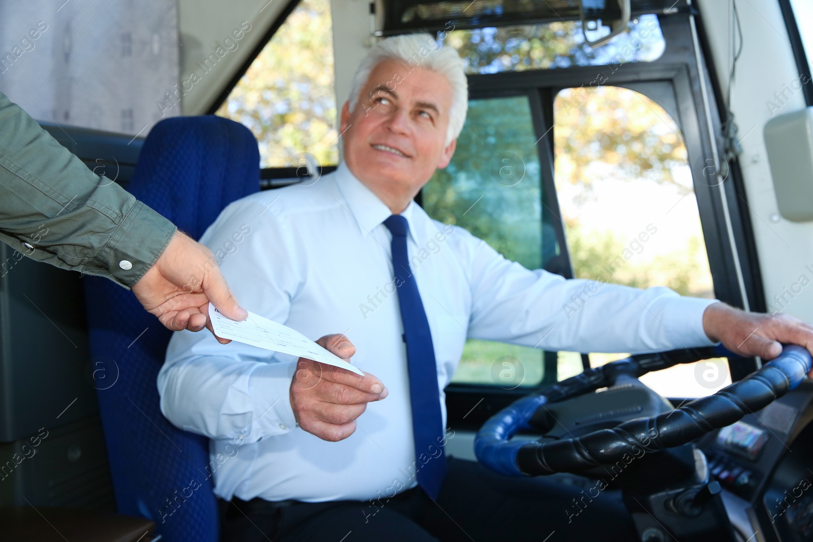 Photo of Professional driver taking ticket from passenger in bus