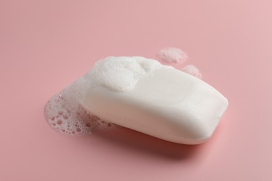 Soap with fluffy foam on pink background