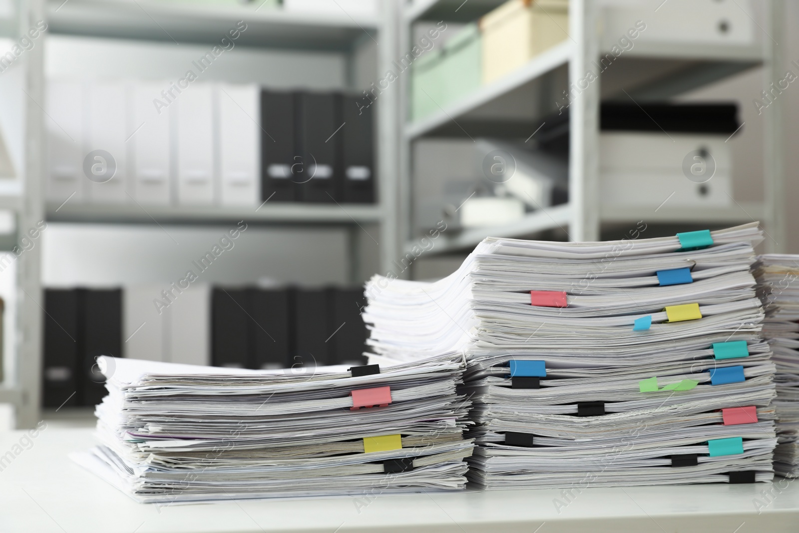 Photo of Stacks of documents with paper clips on office desk